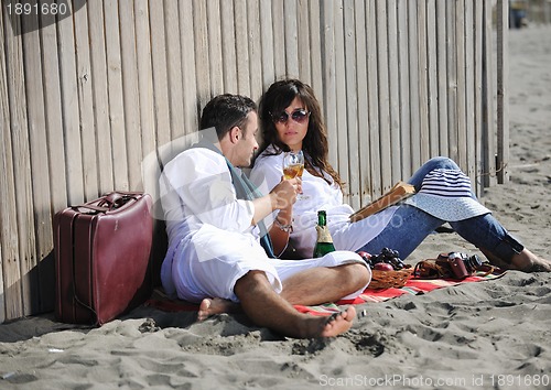 Image of young couple enjoying  picnic on the beach