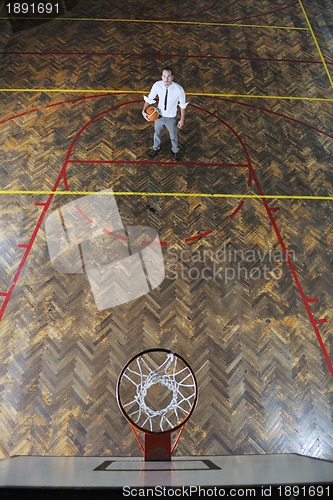 Image of businessman holding basketball ball