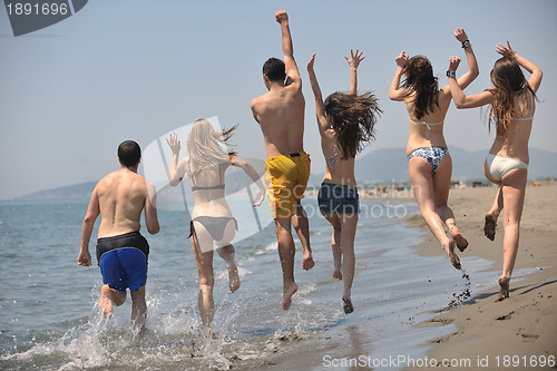 Image of happy people group have fun and running on beach