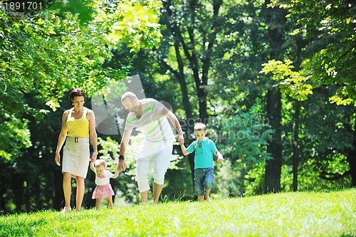 Image of happy young couple with their children have fun at park