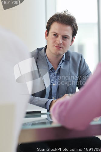 Image of young business man alone in conference room
