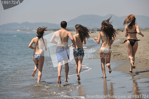 Image of happy people group have fun and running on beach