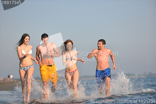 Image of happy people group have fun and running on beach