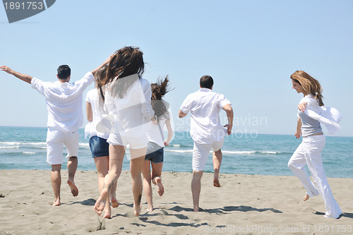 Image of happy people group have fun and running on beach
