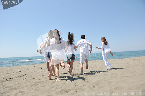 Image of happy people group have fun and running on beach