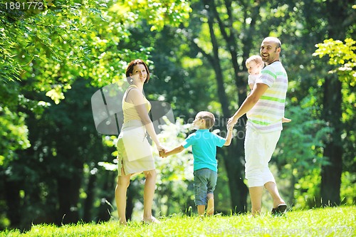 Image of happy young couple with their children have fun at park