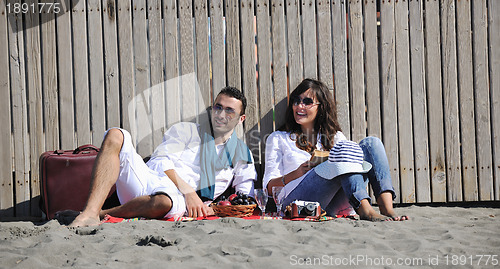 Image of young couple enjoying  picnic on the beach