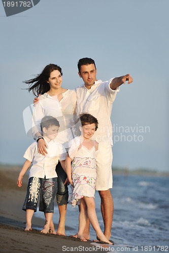 Image of happy young family have fun on beach at sunset