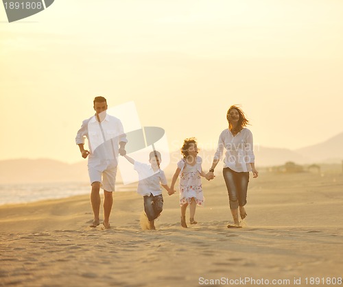 Image of happy young family have fun on beach at sunset