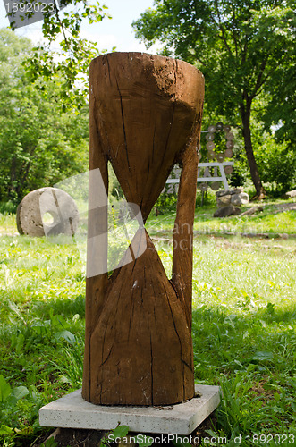 Image of Wooden sandglass imitation closeup and millstone 