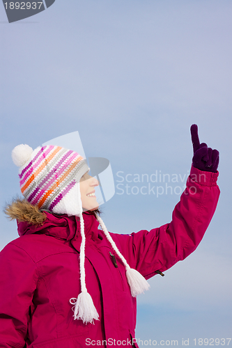 Image of Girl in witer clothes pointing upwards
