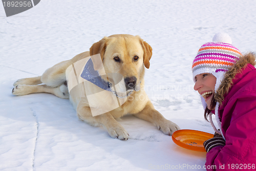 Image of Girl laying with dog in snow