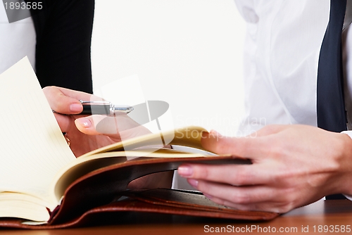 Image of Woman writing in organizer