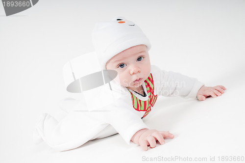 Image of Baby in snowman costume lying on the floor