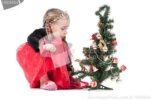 Image of Cute girl sitting with christmas tree