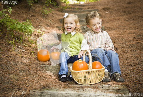 Image of Brother and Sister Children Sitting on Wood Steps with Pumpkins