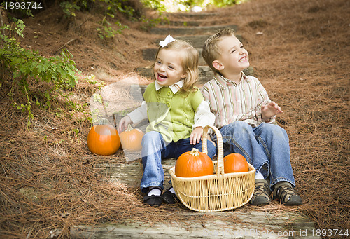Image of Brother and Sister Children Sitting on Wood Steps with Pumpkins
