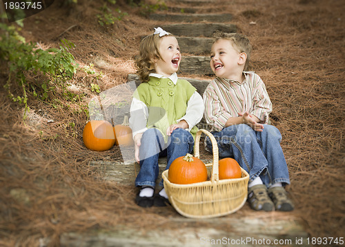 Image of Brother and Sister Children Sitting on Wood Steps with Pumpkins