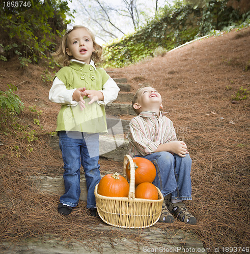 Image of Brother and Sister Children on Wood Steps with Pumpkins Singing