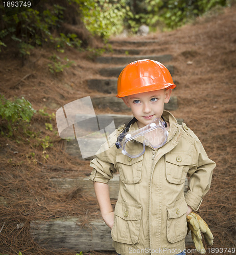 Image of Adorable Child Boy with Big Gloves Playing Handyman Outside