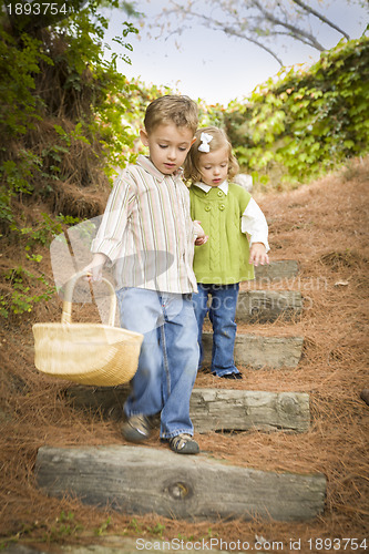 Image of Two Children Walking Down Wood Steps with Basket Outside.