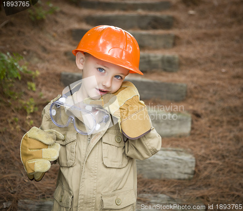 Image of Adorable Child Boy with Big Gloves Playing Handyman Outside