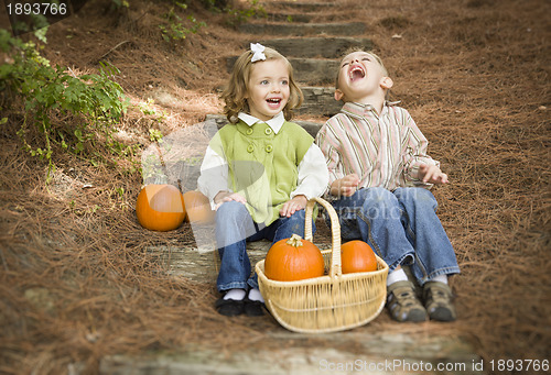 Image of Brother and Sister Children Sitting on Wood Steps with Pumpkins