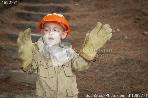 Image of Adorable Child Boy with Big Gloves Playing Handyman Outside