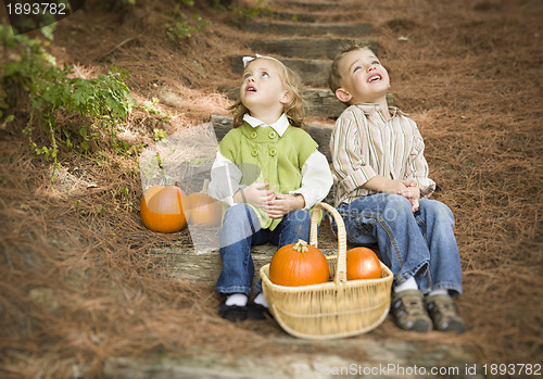 Image of Brother and Sister Children on Wood Steps with Pumpkins Singing