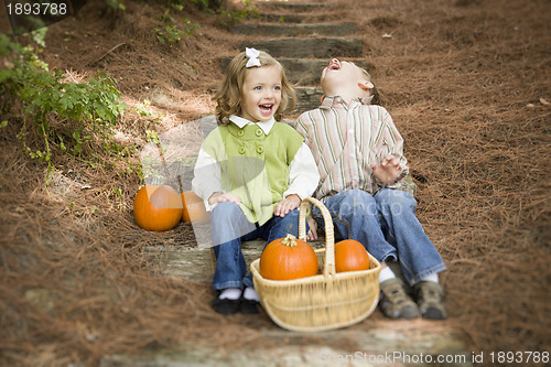 Image of Brother and Sister Children Sitting on Wood Steps with Pumpkins