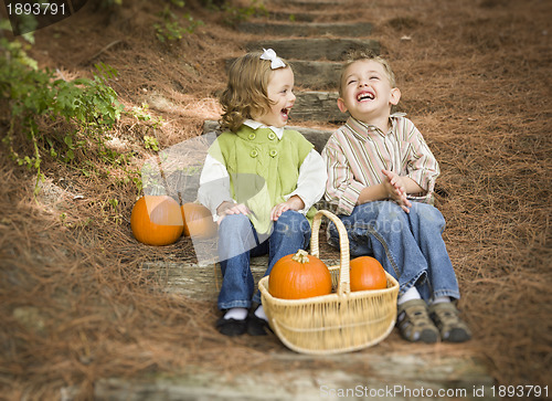 Image of Brother and Sister Children Sitting on Wood Steps with Pumpkins