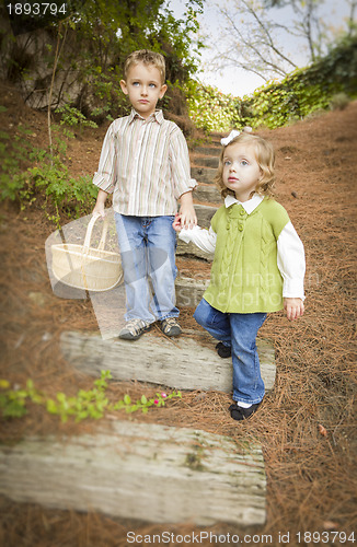 Image of Two Children Walking Down Wood Steps with Basket Outside.