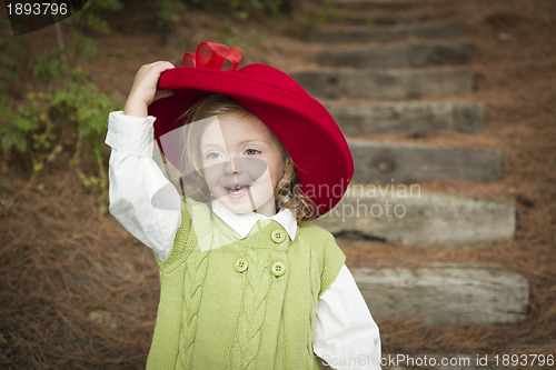 Image of Adorable Child Girl with Red Hat Playing Outside