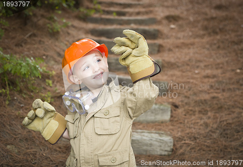 Image of Adorable Child Boy with Big Gloves Playing Handyman Outside