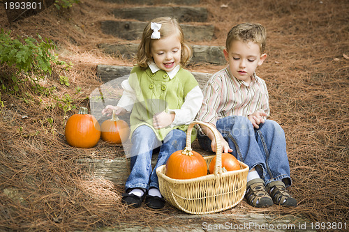 Image of Brother and Sister Children Sitting on Wood Steps with Pumpkins