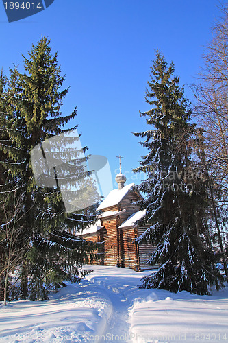 Image of wooden chapel amongst snow tree