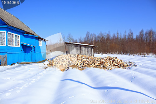 Image of damp firewood near rural building 