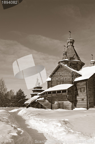 Image of wooden chapel in winter village, sepia