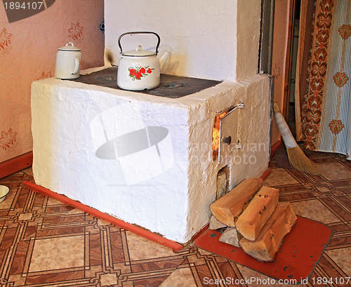 Image of brick stove in rural wooden house 