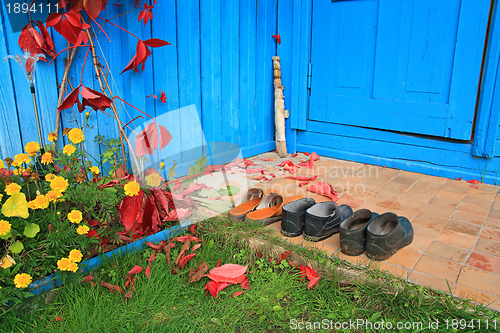 Image of aging footwear on porch of the rural building