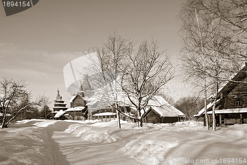 Image of wooden chapel in winter village, sepia