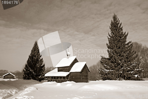 Image of wooden chapel in winter village, sepia