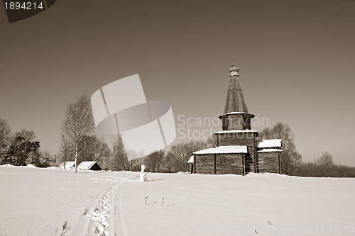 Image of wooden chapel on snow field, sepia