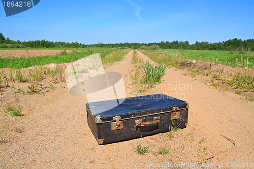 Image of old valise on rural road 