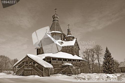 Image of wooden chapel in winter village, sepia