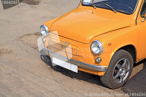 Image of old orange car on town street