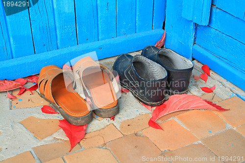 Image of aging footwear on porch of the rural building