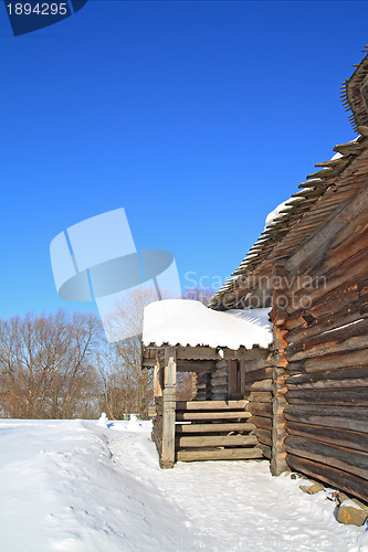 Image of rural wooden house amongst snow