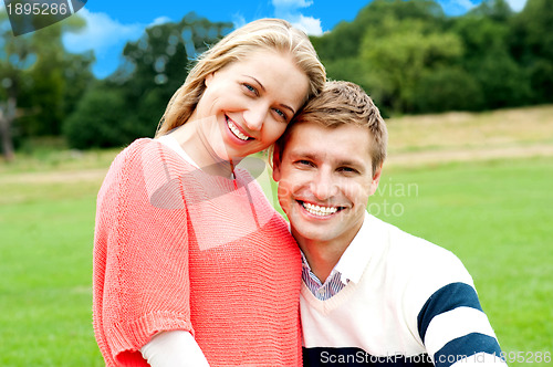 Image of Young couple outdoors sitting on green grass