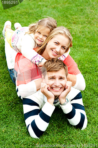 Image of Husband, wife and child piled on each other